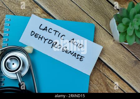 Concept d'acide lactique déshydrogénase écrire sur des notes adhésives avec stéthoscope isolé sur la table en bois. Banque D'Images
