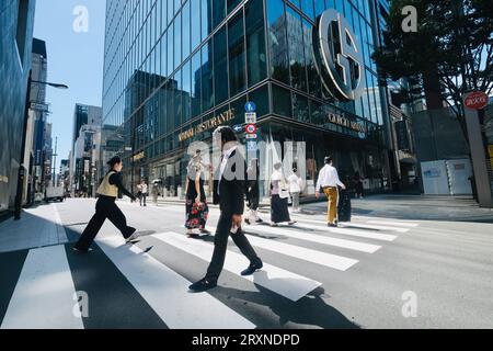 Les gens traversent un passage piéton à Ginza, Tokyo, Japon Banque D'Images