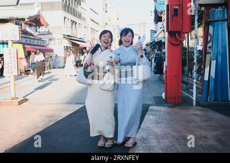 Deux japonaises vêtues de kimonos se tiennent sur la route à Asakusa à Tokyo, au Japon Banque D'Images