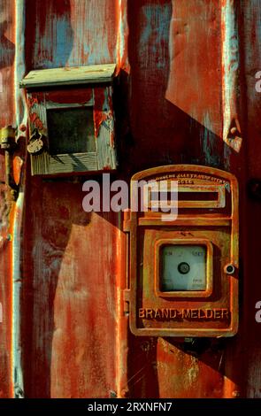 Vieille alarme incendie, détecteur d'incendie et boîte à clés sur la porte rouge Banque D'Images