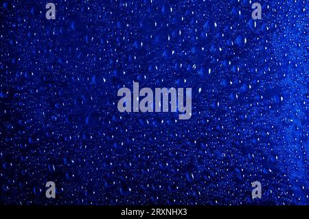 De nombreuses gouttes d'eau sur un fond bleu foncé Banque D'Images