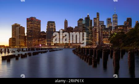 Paysage urbain panoramique sur les gratte-ciel de Lower Manhattan. La photo prise depuis brooklyn Bridge Park. Incroyable vue sur l'heure bleue et le coucher du soleil sur la gauche Banque D'Images