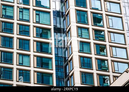 Gratte-ciel à l'architecture d'avant-garde avec garniture en verre teinté dans un cadre métallique reflète comme dans un miroir d'un bâtiment sur le côté opposé de la st Banque D'Images