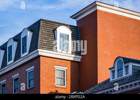 Un ancien bâtiment colonial classique en brique rouge à plusieurs étages construit de forme géométrique stricte avec des quartiers d'habitation dans le grenier dans la limite de la ville de Cambridge i Banque D'Images