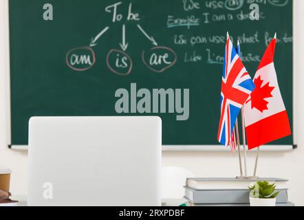 Différents drapeaux avec des livres sur la table dans la salle de classe anglaise Banque D'Images