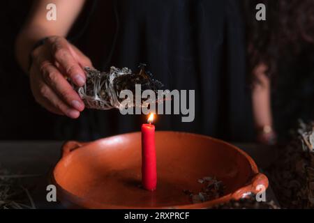 Allumer un encens, , sorcière à la veille de la veille de tous les saints exécutant un rituel de nettoyage, Halloween, croyances spirituelles, magie blanche Banque D'Images