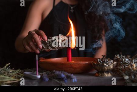 Allumer un encens, , sorcière à la veille de la veille de tous les saints exécutant un rituel de nettoyage, Halloween, croyances spirituelles, magie blanche Banque D'Images