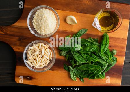 Pesto Ingrédients sur une planche à découper en bois : une variation sur le pesto traditionnel fait avec des amandes effilées au lieu de pignons de pin Banque D'Images