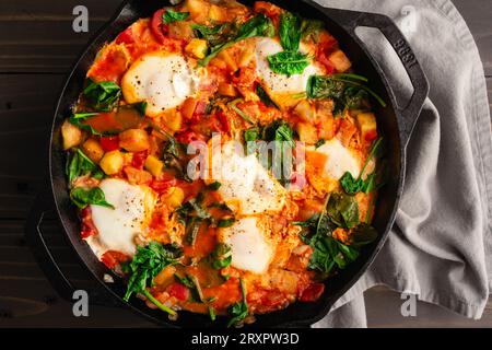 Poêle Ratatouille brunch avec œufs et épinards : aubergines, courgettes, poivrons et ragoût de tomates dans une poêle en fonte Banque D'Images