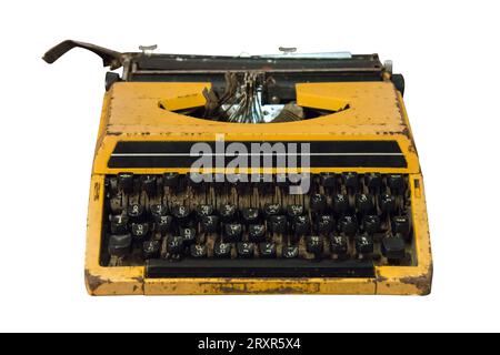 Machine à écrire rouillée jaune ancien et vintage isolée sur fond blanc, fonctionne avec un chemin de coupure. Banque D'Images