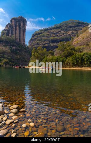 Une rive rocheuse sur la rivière Nine Bend ou Jiuxi à Wuyishan ou la région pittoresque du mont wuyi à Wuyi en Chine dans la province de fujian. Ciel bleu profond, image verticale Banque D'Images