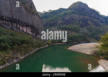 Gros plan sur les formations rocheuses bordant la rivière Nine Bend ou Jiuxi à Wuyishan ou le Mont wuyi région pittoresque à Wuyi Chine dans la province de fujian, coucher de soleil ciel avec Banque D'Images