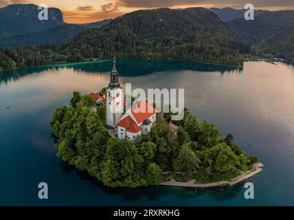 Bled, Slovénie - vue aérienne de l'église de pèlerinage de l'Assomption de Maria au lac de Bled (Blejsko Jezero) avec les Alpes Juliennes à l'arrière-groupe sur un été a Banque D'Images