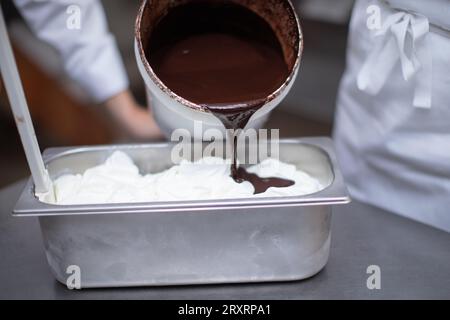 chef versant du chocolat sur la crème glacée Banque D'Images