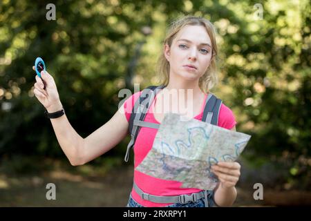 portrait d'une jeune femme randonneur avec boussole et carte Banque D'Images