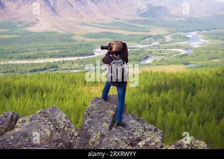 YAMAL, RUSSIE - 20 AOÛT 2018 : un photographe dans les montagnes de l'Oural polaire photographie la vallée de la rivière Sob Banque D'Images