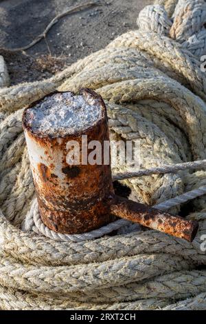 cordes et borne rouillée sur un quai dans un port. Banque D'Images