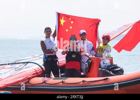 NINGBO, 27 septembre 2023 (Xinhua) -- Bi Kun (1e L) de Chine célèbre sa victoire lors de la finale de voile iQFoil de planche à voile masculine aux 19e Jeux asiatiques à Ningbo, dans la province du Zhejiang, dans l'est de la Chine, le 27 septembre 2023. (Xinhua/Zhang Tao) Banque D'Images