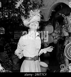 Audrey Hepburn magasinant dans le marché mexicain, Los Angeles, par Earl Theisen, 1954 Audrey Hepburn essayant un chapeau dans un marché mexicain. Image tirée de la mission de photographie look avec le titre : Audrey Hepburn. Banque D'Images