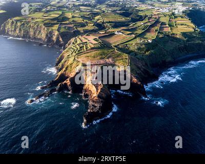 Vue aérienne des côtes et des falaises de l'île de Sao Miguel au-dessus du phare de Farolim dos Fenais da Ajuda, îles Açores, Portugal Banque D'Images