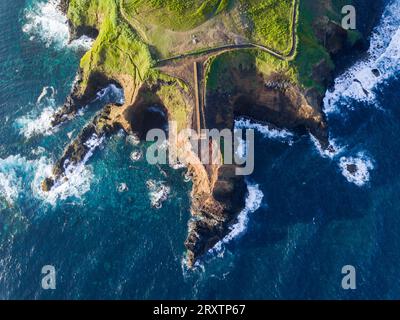 Vue aérienne des côtes et des falaises de l'île de Sao Miguel au-dessus du phare de Farolim dos Fenais da Ajuda, îles Açores, Portugal Banque D'Images