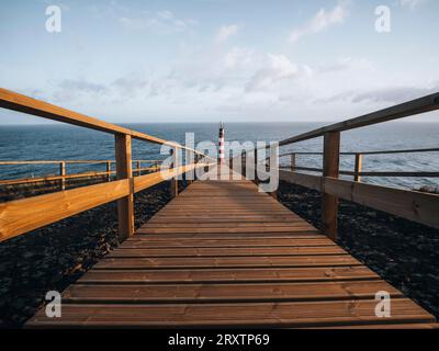 Phare de Farolim dos Fenais da Ajuda avec un chemin symétrique en bois menant à lui, île de Sao Miguel, îles des Açores, Portugal, Atlantique, Europe Banque D'Images