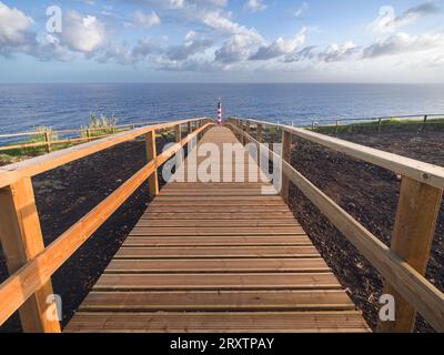 Phare de Farolim dos Fenais da Ajuda avec un chemin symétrique en bois menant à lui, île de Sao Miguel, îles des Açores, Portugal, Atlantique, Europe Banque D'Images