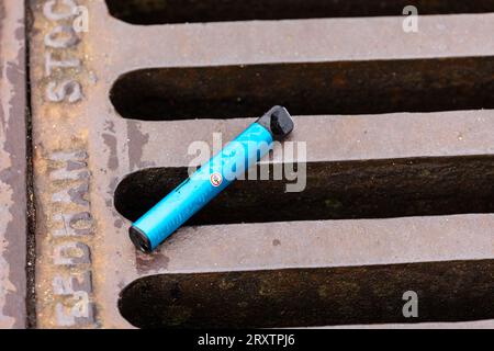 Vape jetable à usage unique couchée sur un drain routier Banque D'Images