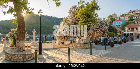 Vue du restaurant côté port et des maisons colorées à Assos en heure d'or, Assos, Céphalonie, îles Ioniennes, îles grecques, Grèce, Europe Banque D'Images