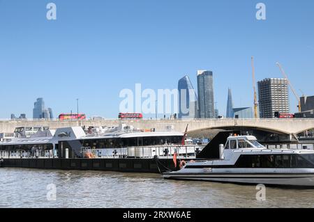 Vue depuis Victoria Embankment par une journée ensoleillée avec des bateaux sur la Tamise, des gratte-ciel sur les toits de Londres et des bus rouges traversant le pont de Waterloo. ROYAUME-UNI Banque D'Images