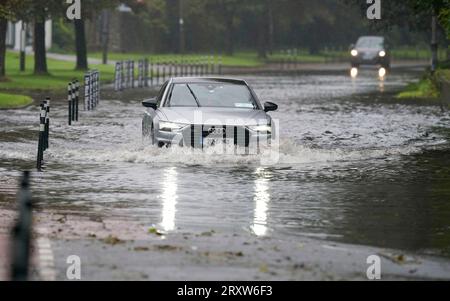 Une voiture roulant dans les eaux de crue à Cork. Les avertissements météorologiques entreront en vigueur alors que le Royaume-Uni et l'Irlande se préparent à l'arrivée de la tempête Agnes, qui apportera des vents dévastateurs et de grandes mers orageuses. Agnès, la première tempête nommée de la saison, affectera les régions occidentales du Royaume-Uni et de l'Irlande, avec les vents les plus puissants attendus sur les côtes de la mer d'Irlande. Date de la photo : mardi 26 septembre 2023. Banque D'Images