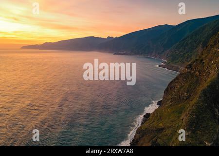 Fantastique vue de carte postale de la côte escarpée de Madère près de Seixal, Portugal, se levant majestueusement de la mer avec un beau lever de soleil en arrière-plan Banque D'Images