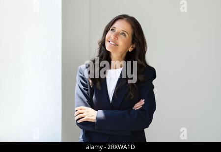 Portrait d'une femme leader mûre brune attrayante posant au bureau Banque D'Images