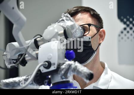 dentiste utilise le microscope dentaire dans la clinique dentaire Banque D'Images