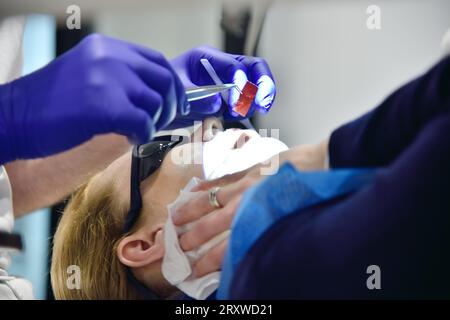 Dentiste traitant la femme patient dans la clinique dentaire moderne. Gros plan Banque D'Images