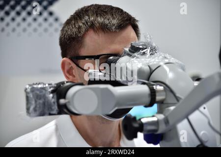 dentiste utilise le microscope dentaire dans le cabinet dentaire Banque D'Images