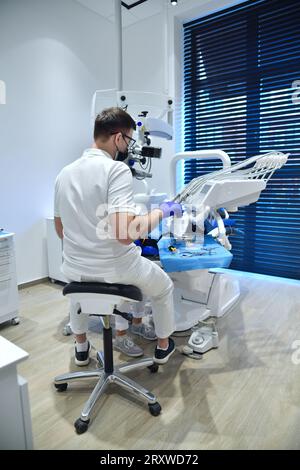 Chirurgien dentiste en uniforme et infirmière exécutant l'opération installer les dents d'implant dentaire du patient de femme. Banque D'Images