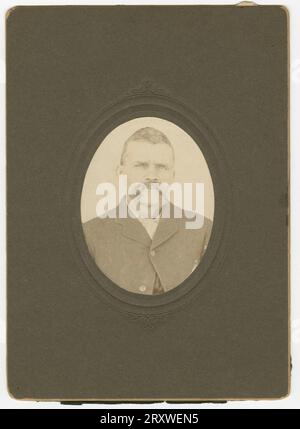 Photographie d'un homme avec une moustache portant une veste foncée Banque D'Images