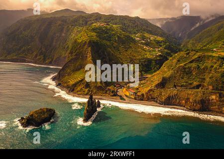 Vue aérienne panoramique de l'océan Atlantique s'écrasant contre la côte et sur l'île rocheuse Ilheus da Rib au large de Ribeira da Janela à Madère, Portugal Banque D'Images