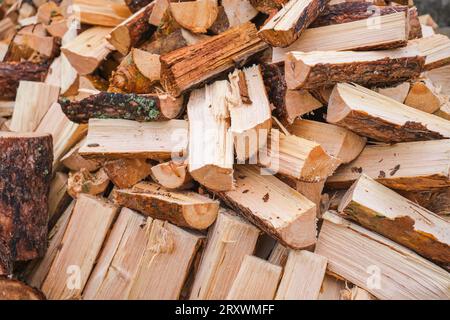 Fond en bois naturel, gros plan de bois de chauffage de pin haché empilé dans un tas, préparé pour l'hiver Banque D'Images