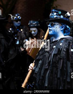 Morris danseurs avec le maquillage complet et les visages peints et jouant de l'accordéon. Costumes traditionnels de danse folklorique sombre avec chapeaux hauts et lunettes de soleil Banque D'Images