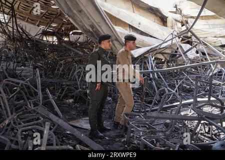 27 septembre 2023, Irak, Hamdaniya : des membres des forces de sécurité se tiennent debout dans la salle de mariage incendiée après un incendie mortel qui a englouti la salle lors d'une célébration de mariage. Selon les médias d'État et les responsables de la santé, au moins 100 personnes ont été tuées et plus de 150 blessées lorsqu'un incendie s'est déclaré lors d'un mariage dans une salle de réunion. Photo : Ismael Adnan/dpa Banque D'Images