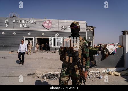 27 septembre 2023, Irak, Hamdaniya : les forces de sécurité se tiennent devant une salle de mariage après un incendie mortel qui a englouti la salle lors d'une célébration de mariage. Au moins 114 personnes ont été tuées et quelque 200 autres blessées lorsqu'un incendie a éclaté lors d'un mariage dans une salle d'événements, selon les médias d'État et les responsables de la santé. Photo : Ismael Adnan/dpa Banque D'Images
