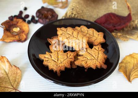 Biscuits à la cannelle et feuilles d'automne sur étagère en bois. Biscuits en pain d'épice en forme de feuilles. Biscuits festifs d'automne. Boulangerie artisanale. Banque D'Images
