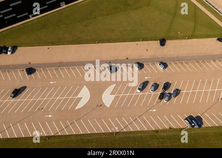 Photographie de drone de grande place de parking d'entrepôt avec quelques voitures garées pendant la journée d'été. Banque D'Images