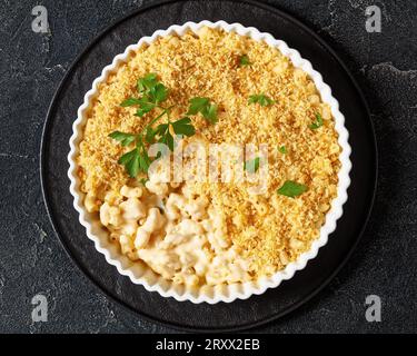 mac cuit au four et fromage saupoudré de chapelure panko et de persil frais dans un plat allant au four sur une table en béton, vue horizontale, mise à plat, gros plan Banque D'Images