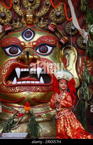 Kumari Pooja au Népal Une jeune fille népalaise pré-pubère pose pour une photo devant Swet Bhairab alors qu'elle assiste à la messe Kumari Pooja organisée à Basantapur Durbar Sqaure - un site du patrimoine mondial de l'UNESCO dans la capitale népalaise Katmandou. Vêtues de robes rouges, la déesse vivante Kumari Newa : les filles s'assoient en ligne pour être adorées tour à tour pour conjurer la malchance et les maladies. Les filles pré-pubères sont adorées chaque année inn la nation himalayenne comme incarnations terrestres de l'énergie féminine divine, manifestations de la déesse connue sous le nom Taleju Bhawani, le nom népalais de la déesse Durga. Droit d'auteur : xSubashxSh Banque D'Images