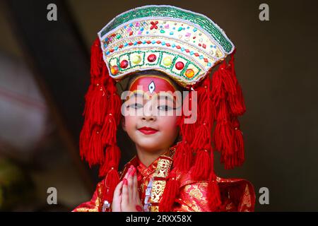 Kumari Pooja au Népal Une jeune fille népalaise pré-pubère pose pour une photo alors qu'elle assiste à la messe Kumari Pooja organisée à Basantapur Durbar Sqaure - un site du patrimoine mondial de l'UNESCO dans la capitale népalaise Katmandou. Vêtues de robes rouges, la déesse vivante Kumari Newa : les filles s'assoient en ligne pour être adorées tour à tour pour conjurer la malchance et les maladies. Les filles pré-pubères sont adorées chaque année inn la nation himalayenne comme incarnations terrestres de l'énergie féminine divine, manifestations de la déesse connue sous le nom Taleju Bhawani, le nom népalais de la déesse Durga. Droit d'auteur : xSubashxShresthax Banque D'Images