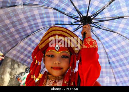 Kumari Pooja au Népal Une jeune fille népalaise pré-pubère pose pour une photo alors qu'elle assiste à la messe Kumari Pooja organisée à Basantapur Durbar Sqaure - un site du patrimoine mondial de l'UNESCO dans la capitale népalaise Katmandou. Vêtues de robes rouges, la déesse vivante Kumari Newa : les filles s'assoient en ligne pour être adorées tour à tour pour conjurer la malchance et les maladies. Les filles pré-pubères sont adorées chaque année inn la nation himalayenne comme incarnations terrestres de l'énergie féminine divine, manifestations de la déesse connue sous le nom Taleju Bhawani, le nom népalais de la déesse Durga. Droit d'auteur : xSubashxShresthax Banque D'Images