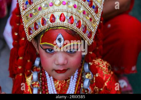 Kumari Pooja au Népal Une jeune fille népalaise pré-pubère pose pour une photo alors qu'elle assiste à la messe Kumari Pooja organisée à Basantapur Durbar Sqaure - un site du patrimoine mondial de l'UNESCO dans la capitale népalaise Katmandou. Vêtues de robes rouges, la déesse vivante Kumari Newa : les filles s'assoient en ligne pour être adorées tour à tour pour conjurer la malchance et les maladies. Les filles pré-pubères sont adorées chaque année inn la nation himalayenne comme incarnations terrestres de l'énergie féminine divine, manifestations de la déesse connue sous le nom Taleju Bhawani, le nom népalais de la déesse Durga. Droit d'auteur : xSubashxShresthax Banque D'Images